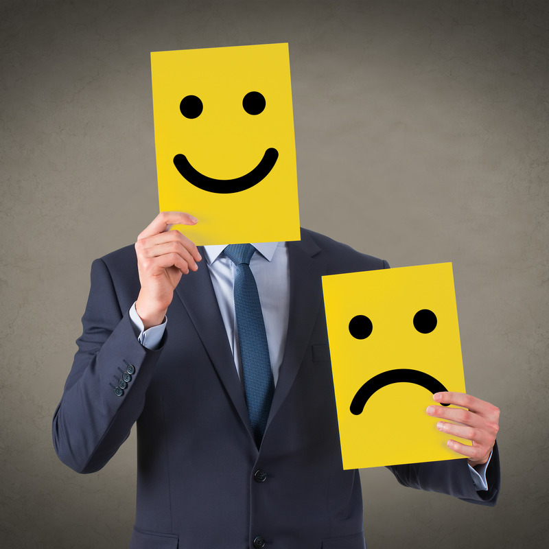 Happy and unhappy drawn faces hiding a business man